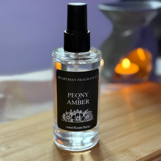 Peony Amber room spray bottle on a wooden surface with a blurred background
