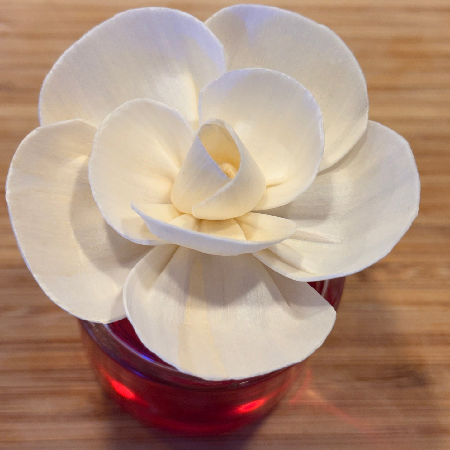 White flower reed diffuser on a wooden surface. Vanilla and Jasmine Mothers day edition from Heartman Fragrances.