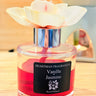 Vanilla Jasmine fragrance bottle with a flower on a wooden surface